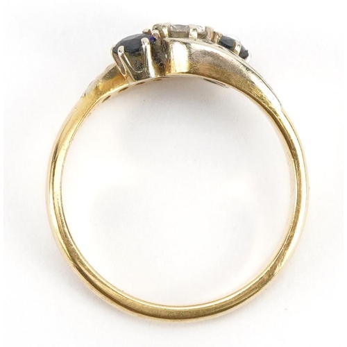 3034 - 18ct gold diamond and sapphire three stone crossover ring with diamond set shoulders, the diamond ap... 