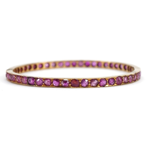 3055 - Unmarked gold ruby hinged bangle, possibly Victorian, tests as 15ct gold, 5.7cm in diameter, 12.0g