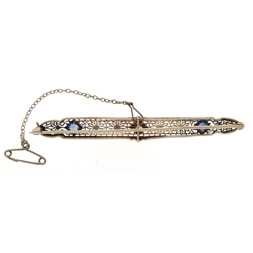 3057 - Art Deco unmarked white metal diamond and sapphire filigree bar brooch with safety chain, the diamon... 