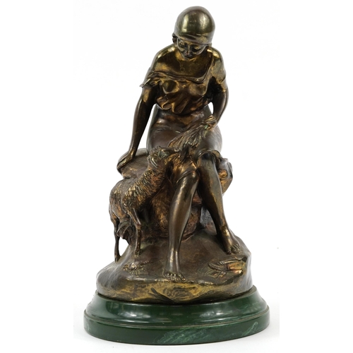 1353 - Bronzed study of a shepherdess with sheep raised on a green marbleised base, 32cm high