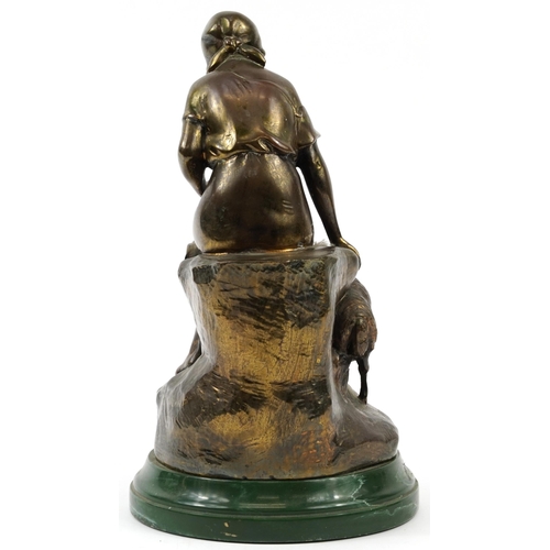 1353 - Bronzed study of a shepherdess with sheep raised on a green marbleised base, 32cm high