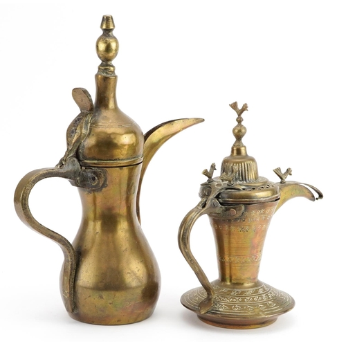 230 - Two Omani brass dallah coffee pots including one with impressed decoration, the largest 31cm high