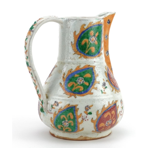 63 - Turkish Ottoman Kutahya pottery jug hand painted with stylised leaves, 20cm high