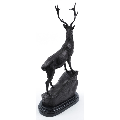 111 - Large patinated bronze stag raised on a black marble base, 73cm high