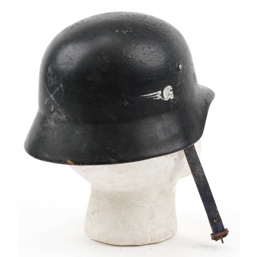 854 - German military interest tin helmet with painted inscriptions and leather strap