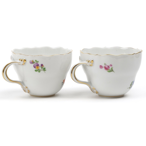43 - Meissen, German porcelain hand painted with flowers including daffodils comprising two cups with sau... 