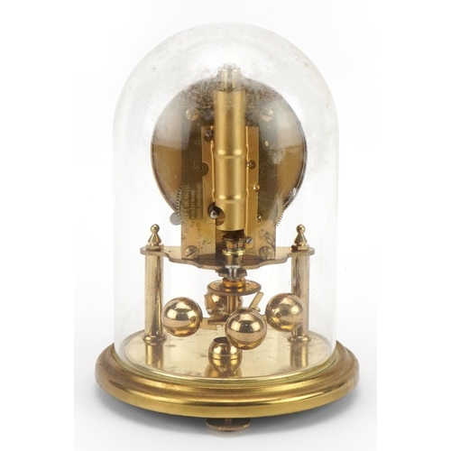 1323 - Kundo brass anniversary clock under a glass dome, 18cm high