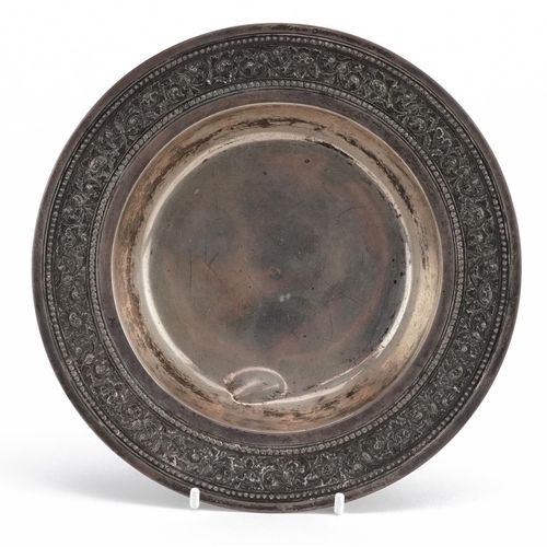 171 - Egyptian circular silver dish with embossed and foliate border, impressed marks to the base, 19cm in... 