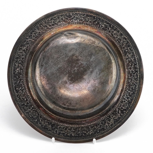 171 - Egyptian circular silver dish with embossed and foliate border, impressed marks to the base, 19cm in... 