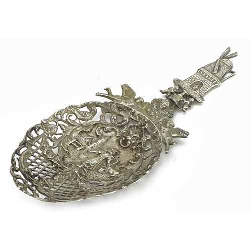 238 - Large Dutch silver pierced spoon embossed with a windmill, winged figures and a farmer with cattle, ... 