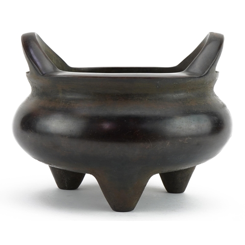 148 - Large Chinese patinated bronze tripod censer with twin handles, four figure character marks to the b... 