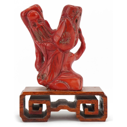 1487 - Chinese coral carving of an elder on hardwood stand, 12.5cm high