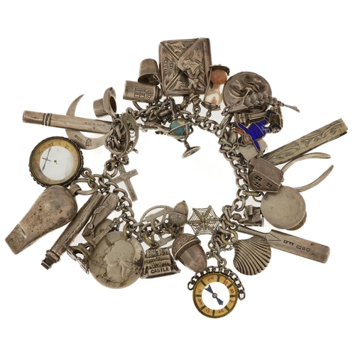 2132 - Large silver charm bracelet with a selection of mostly silver charms including folding pocket knife,... 