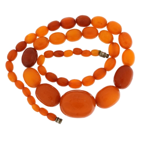 2065 - Butterscotch amber coloured graduated bead necklace, the largest bead 2.5cm wide, 49cm in length, 29... 