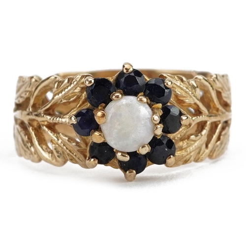 2073 - 9ct gold opal and sapphire two tier flower head ring with pierced leaf design shoulders, the opal ap... 