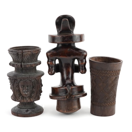 136B - African tribal interest wood carvings including a beaker with geometric design and figure, the large... 