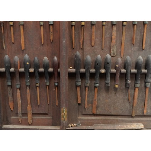 341 - Collection of predominantly rosewood handled woodworking chisels arranged in a mahogany wall hanging... 