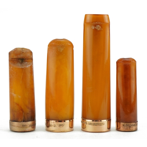 78 - Four late19th/early 20th century butterscotch amber cigarette holders with 9ct gold mounts, each hou... 