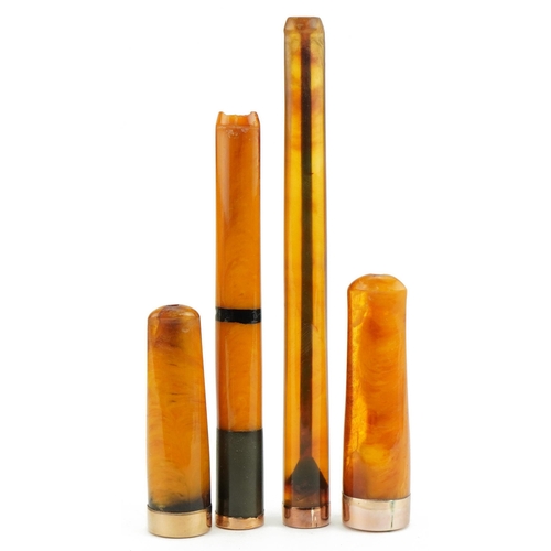 79 - Four late 19th/early 20th century butterscotch amber and amber coloured cigarette holders with 9ct g... 