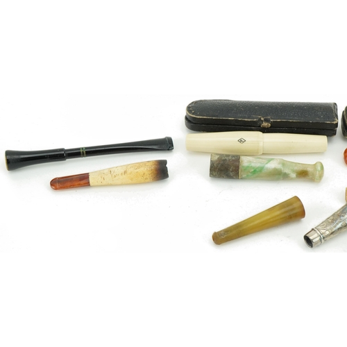 241 - Early 20th century and later cigarette holders and two cases including butterscotch amber examples, ... 