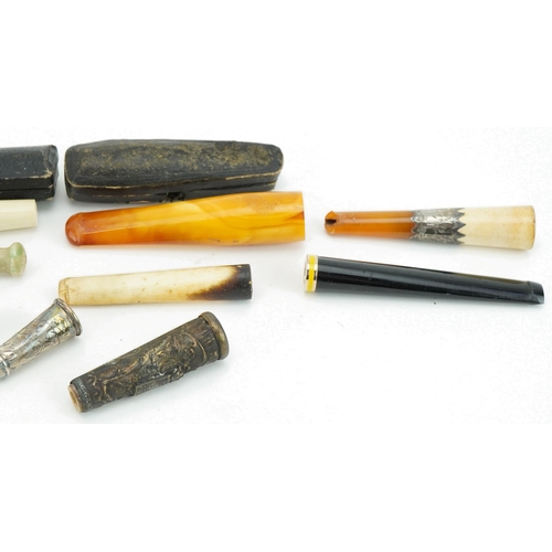 241 - Early 20th century and later cigarette holders and two cases including butterscotch amber examples, ... 