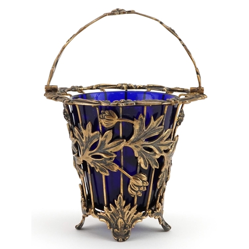 139 - John Henry Odell, Elizabeth II silver gilt basket with swing handle and blue glass liner cast with f... 