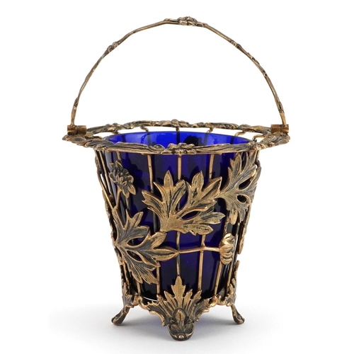 139 - John Henry Odell, Elizabeth II silver gilt basket with swing handle and blue glass liner cast with f... 