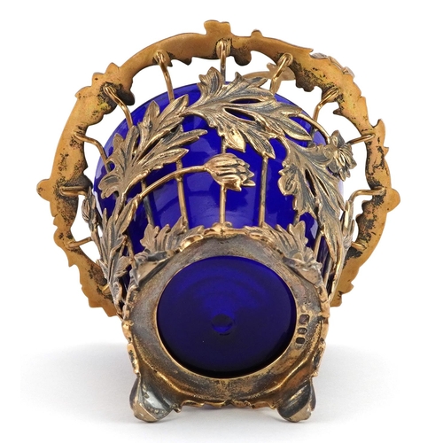 139 - John Henry Odell, Elizabeth II silver gilt basket with swing handle and blue glass liner cast with f... 