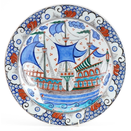 59 - Turkish Iznik pottery plate hand painted with ships and stylised flowers, 31cm in diameter