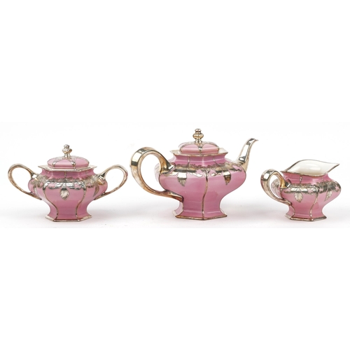 311 - Lenox, American pink glazed porcelain three piece tea set with silver floral overlay comprising teap... 