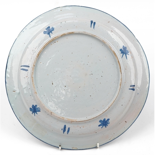 61 - 18th century Delft tin glazed charger hand painted with flowers, 33cm in diameter