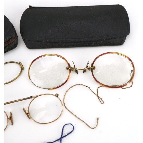 417 - Three pairs of early 20th century spectacles comprising one with tortoiseshell handle and two yellow... 