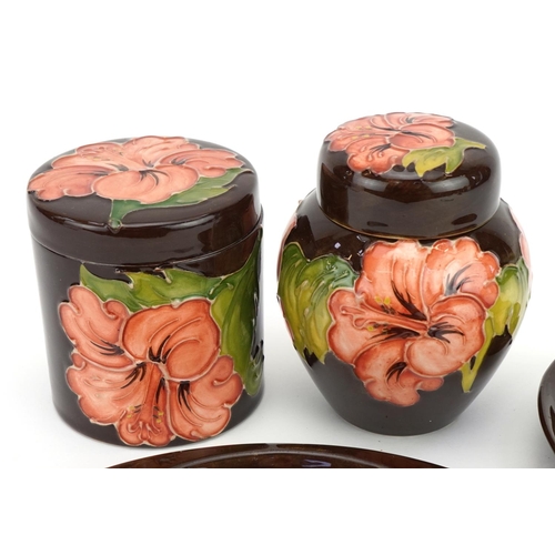 89 - Moorcroft pottery hand painted in the Coral Hibiscus pattern comprising ginger jar and cover, cylind... 