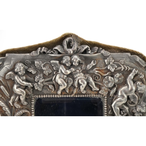 1370 - Pewter mounted easel mirror decorated in relief with a maiden, Putti and flowers, 27cm x 22cm