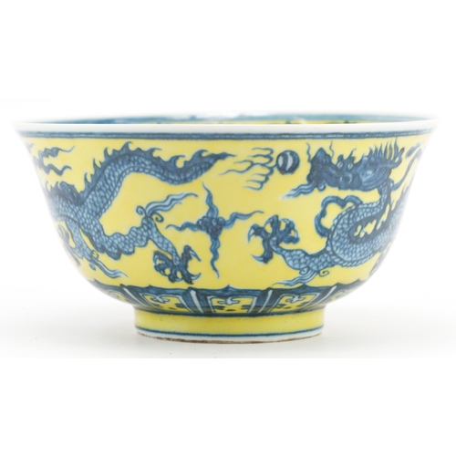 1294 - Chinese porcelain yellow ground bowl hand painted with dragons chasing the flaming pearl, six figure... 