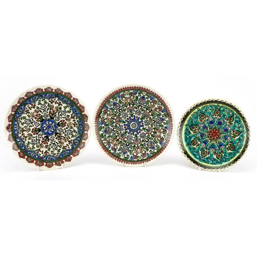 1349 - Three Turkish Kutahya pottery plates hand painted with flowers, the largest each 26cm in diameter