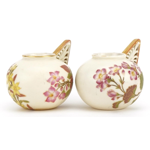 91 - Royal Worcester, pair of Victorian blush ivory vases with pierced handles, each decorated with flowe... 