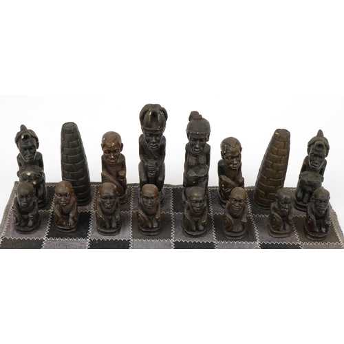 1438 - South African carved stone figural chess set with board, Rhodesia paper label to the base of the che... 