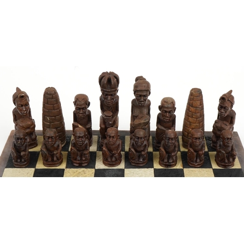 1438 - South African carved stone figural chess set with board, Rhodesia paper label to the base of the che... 