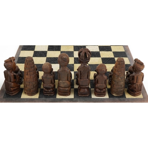 1438 - South African carved stone figural chess set with board, Rhodesia paper label to the base of the che... 