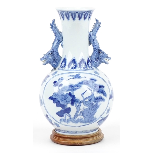 1167 - Chinese blue and white porcelain vase with dragon handles raised on a hardwood stand, decorated with... 