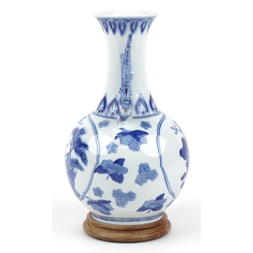 1167 - Chinese blue and white porcelain vase with dragon handles raised on a hardwood stand, decorated with... 