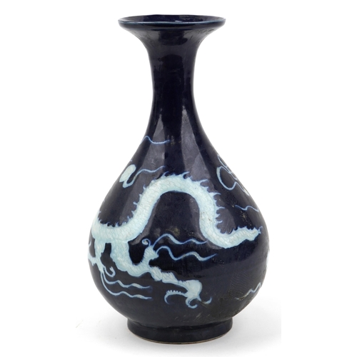 1166 - Chinese porcelain vase having a blue glaze decorated in low relief with a dragon chasing the flaming... 