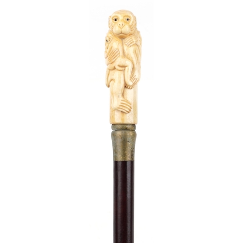 589 - Hardwood walking stick with carved bone and inlaid abalone handle in the form of two monkeys, 90cm i... 