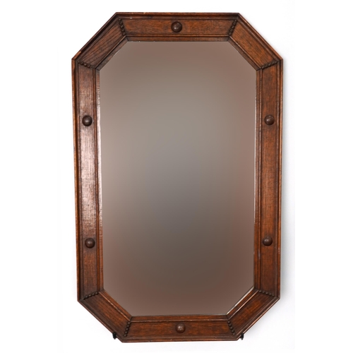 1079 - Arts & Crafts oak octagonal wall hanging mirror with bevelled glass, 82cm x 52cm