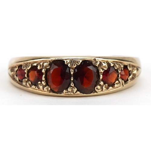 2096 - Victorian style garnet graduated six stone ring with engraved shoulders, the largest garnet approxim... 