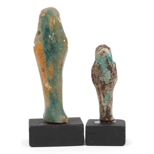 1295 - Two Egyptian style shabtis raised on painted wooden block bases, the largest overall 12cm high