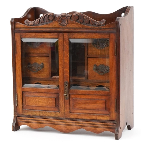 161 - Arts & Crafts oak smoker's cabinet with a pair of glazed doors enclosing four drawers and open shelf... 