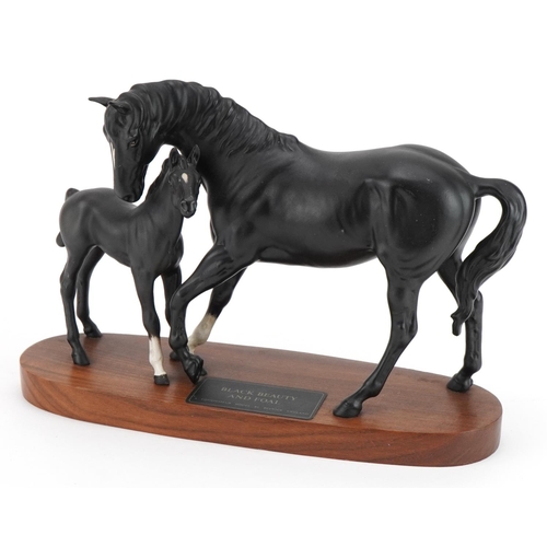 446 - Beswick Connoisseur model of Black Beauty and foal raised on a wooden plinth base, 29.5cm in length