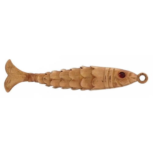 2059 - 9ct gold articulated fish charm with cabochon red stone eyes, 4.0cm in length, 1.9g